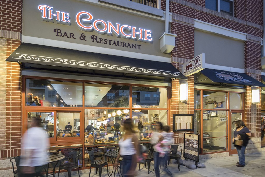 people walking in front of a restaurant on a city street