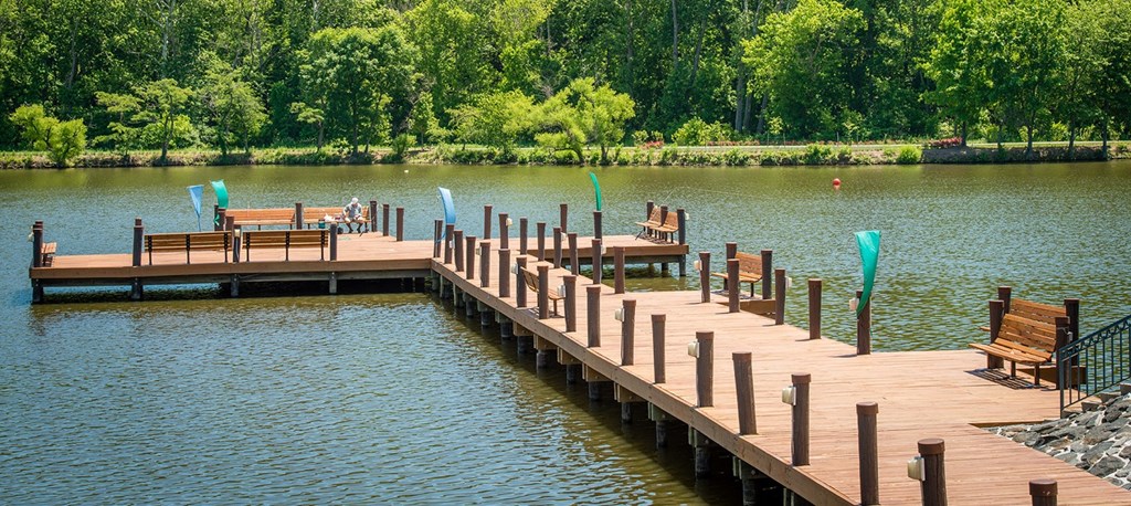 a dock on a lake with chairs on it at The Metropolitan Downtown Columbia, Columbia, Maryland