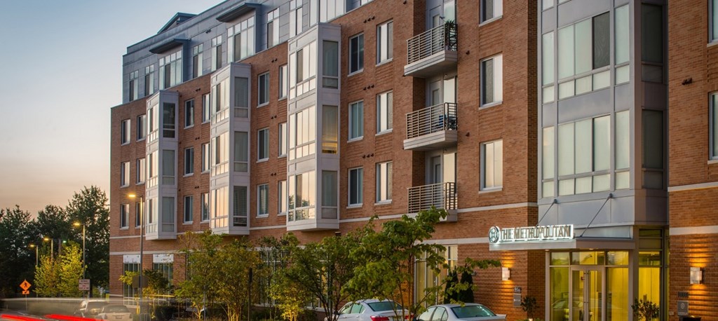 an apartment building on a city street at dusk at The Metropolitan Downtown Columbia, Columbia, MD