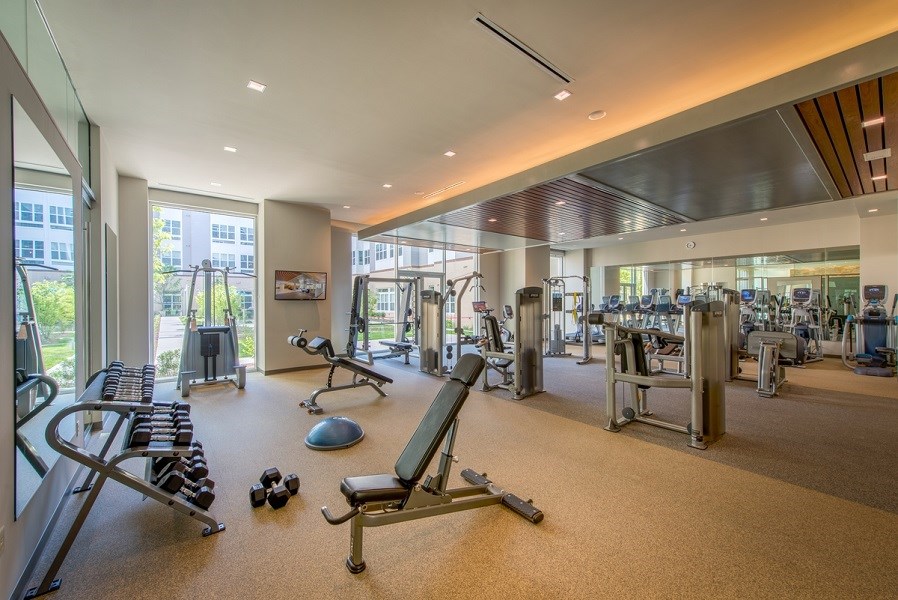 a gym with weights and cardio equipment in a building with glass doors at The Metropolitan Downtown Columbia, Maryland, 21044