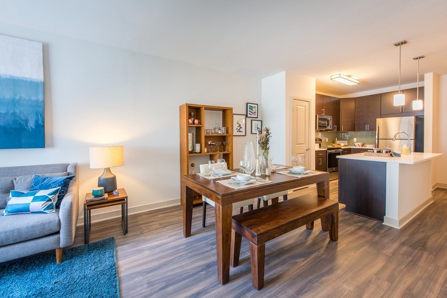 a living room and dining room with a wooden table at The Metropolitan Downtown Columbia, Columbia, 21044