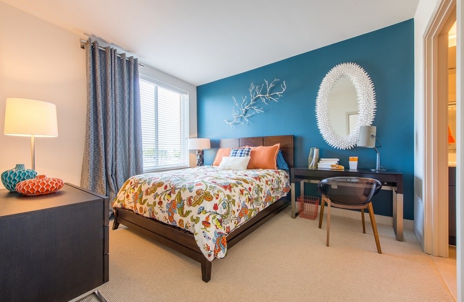 a bedroom with a bed and a desk with a mirror at The Metropolitan Downtown Columbia, Maryland, 21044