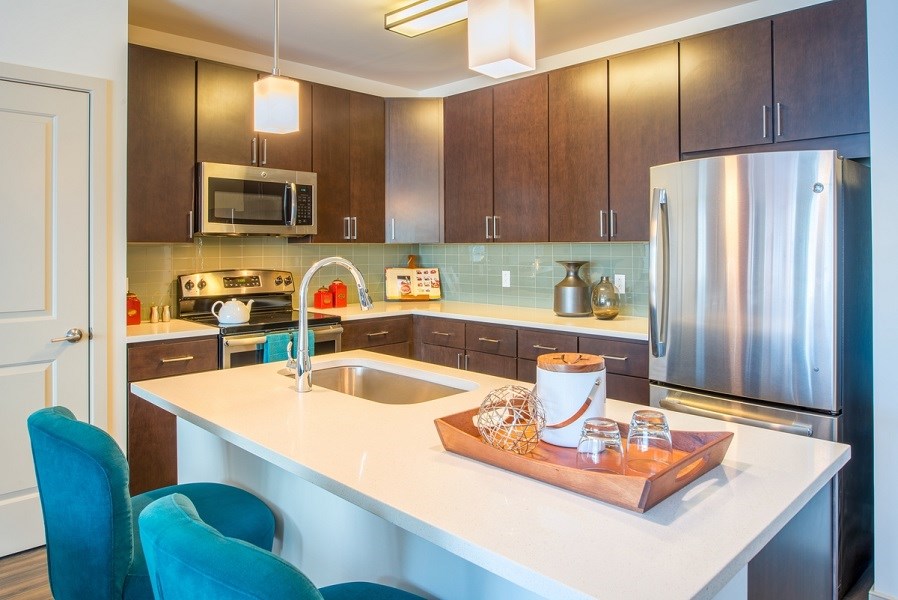 a kitchen with stainless steel appliances and a white counter top at The Metropolitan Downtown Columbia, Columbia, Maryland