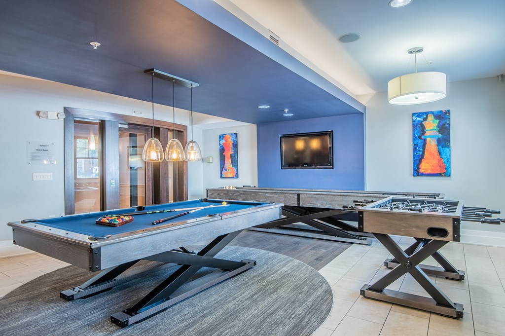 a games room with two pool tables and two foosball tables