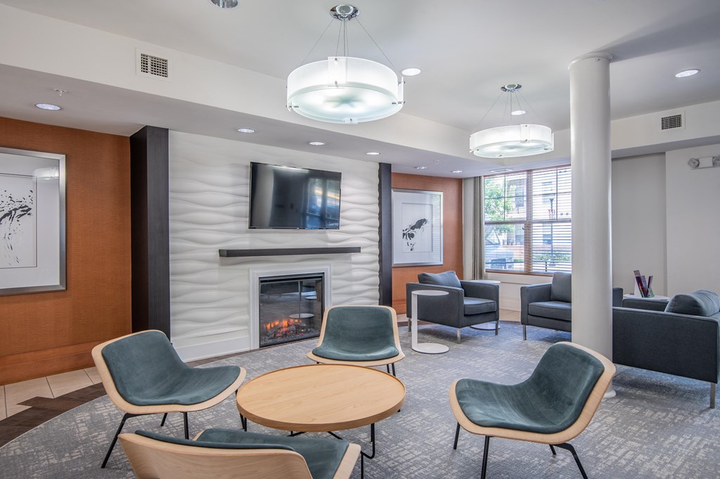 a living room with a fireplace and chairs and a table