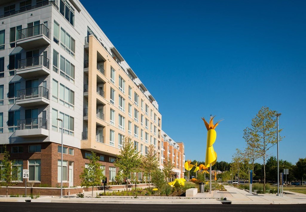 a large yellow sculpture in front of an apartment buildingulpture in front of an apartment buildingulpture in front of an apartment building at The Metropolitan Downtown Columbia, Columbia, MD