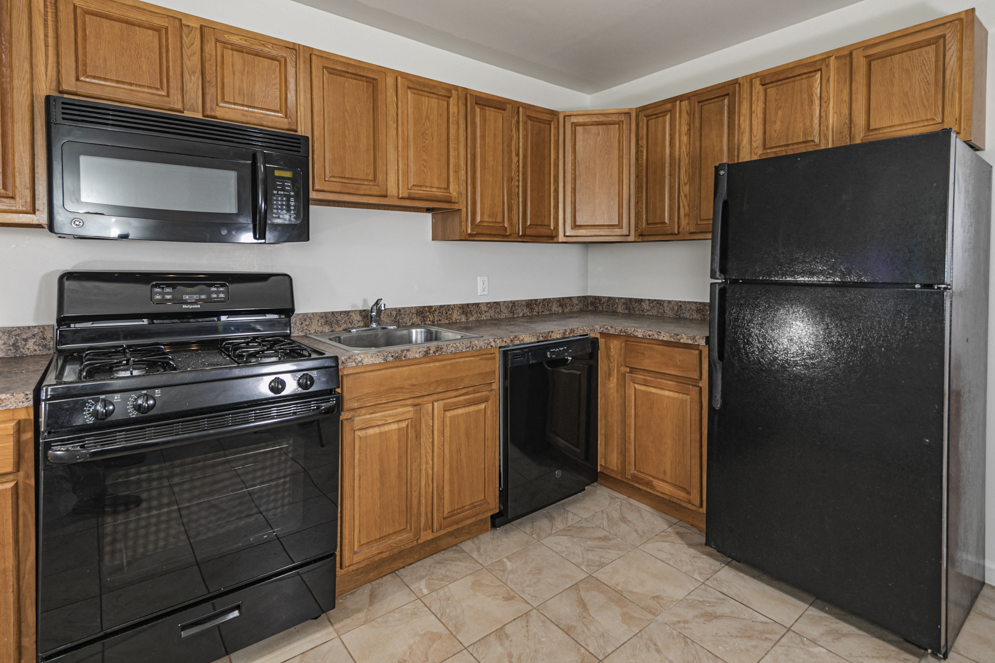a kitchen with black appliances and wooden cabinets