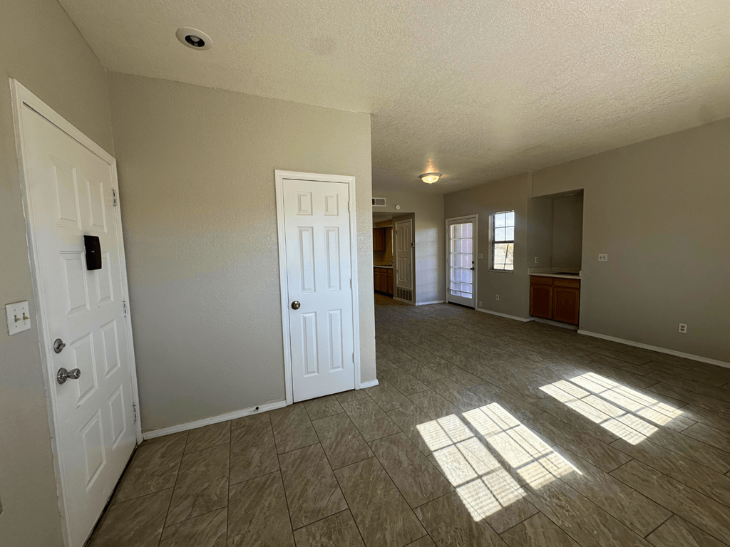 A room with two white doors and a tiled floor.