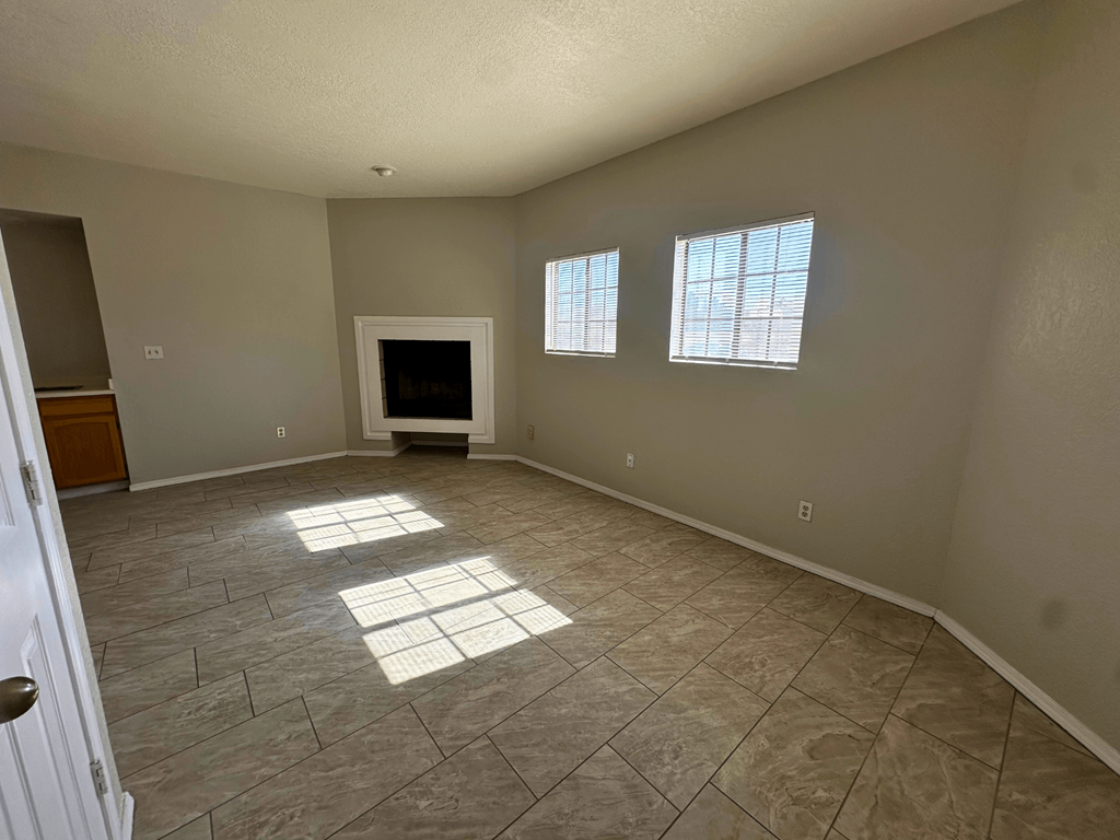 A room with a tiled floor and a flat screen TV.