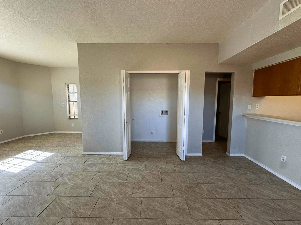 A room with a tiled floor and a doorway leading to another room.