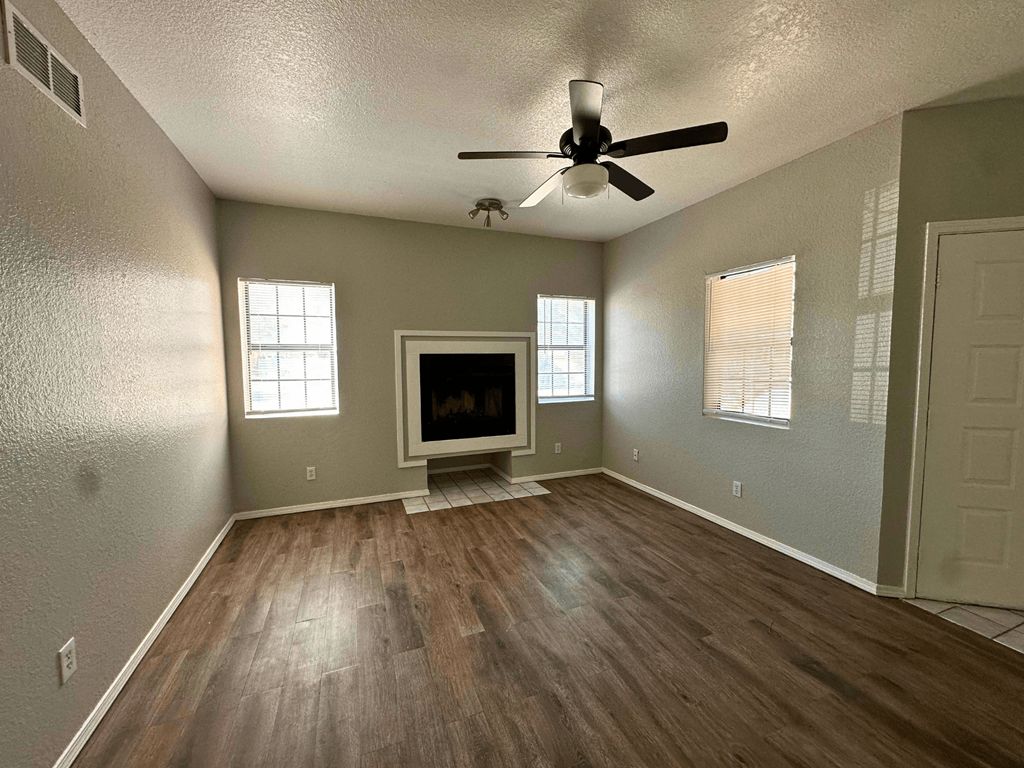 A room with a fireplace and a ceiling fan.