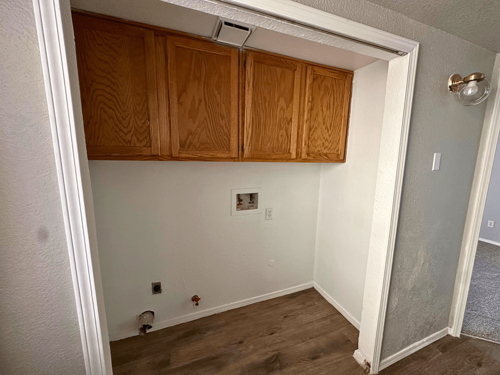 A room with wooden cabinets and a white door.
