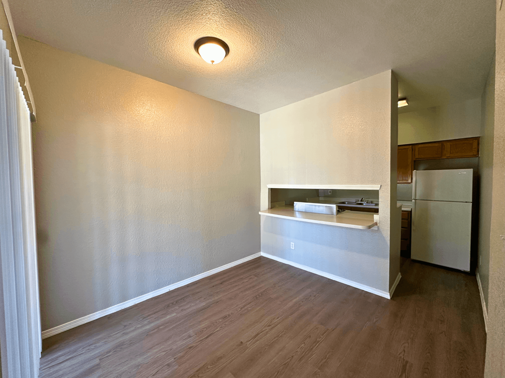 A kitchen area with a refrigerator and a countertop.