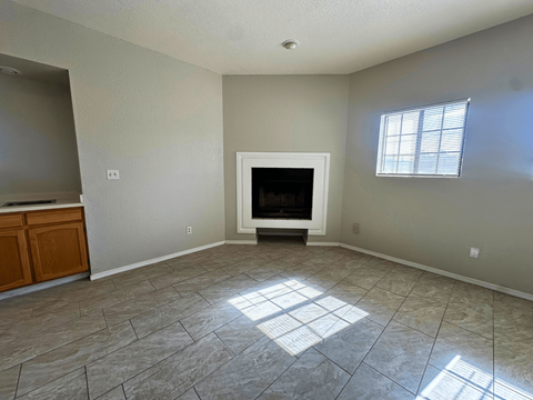 A living room with a fireplace and a window.