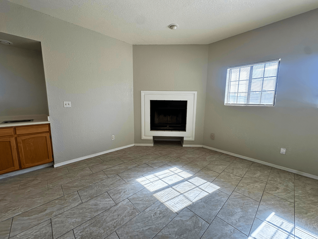 A living room with a fireplace and a window.