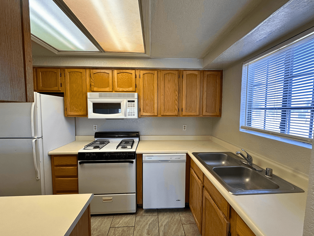 A kitchen with wooden cabinets and stainless steel appliances.