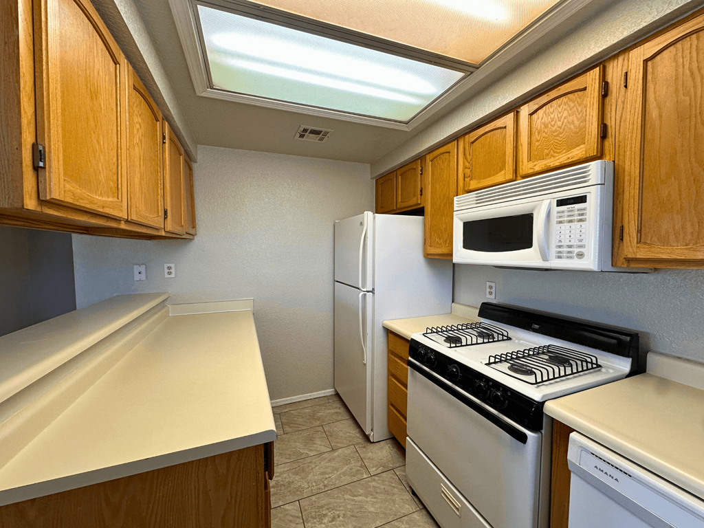 A kitchen with wooden cabinets and white appliances.