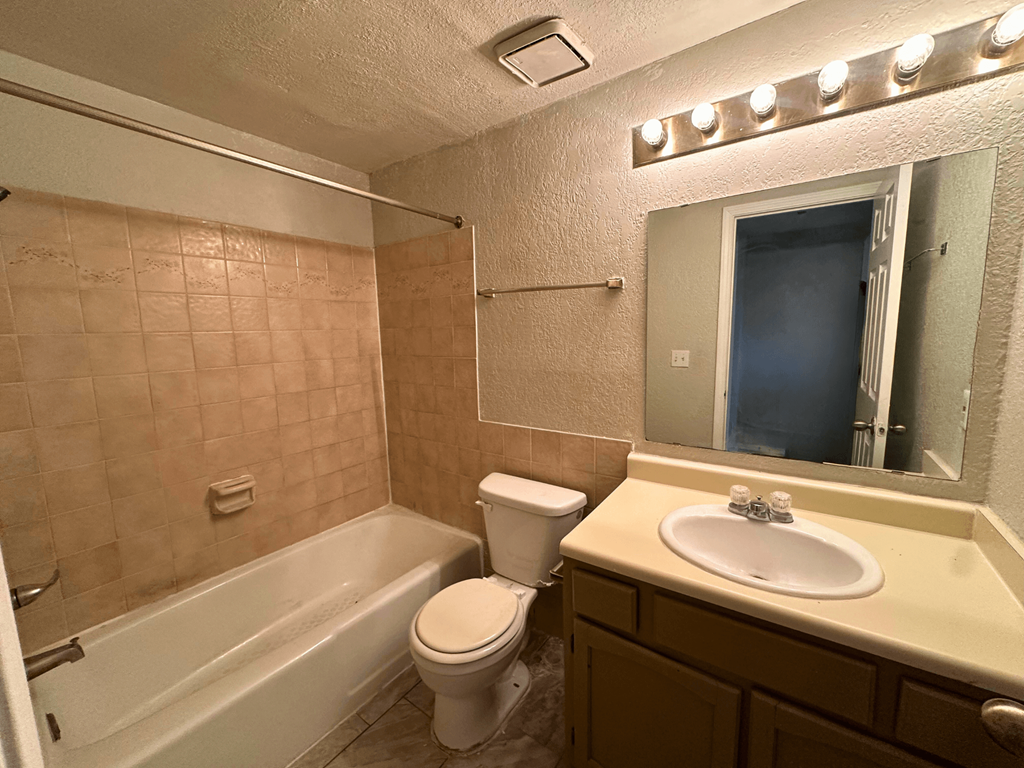 A bathroom with a toilet, sink, and bathtub.