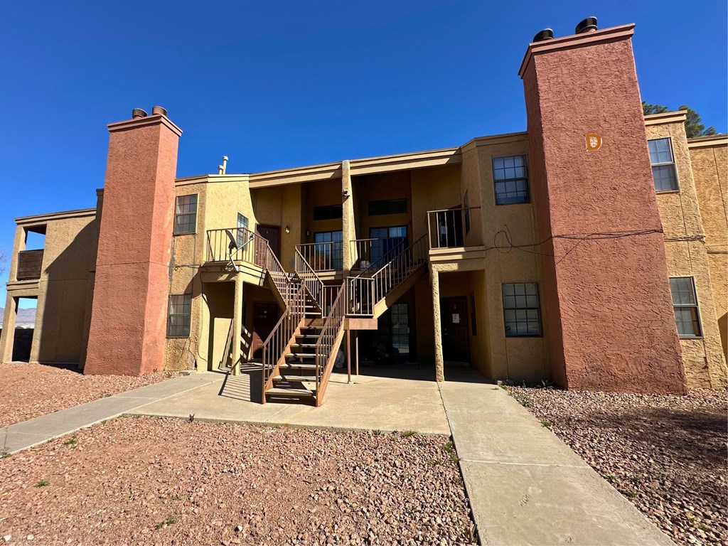 A multi-story apartment building with a staircase leading to the entrance.