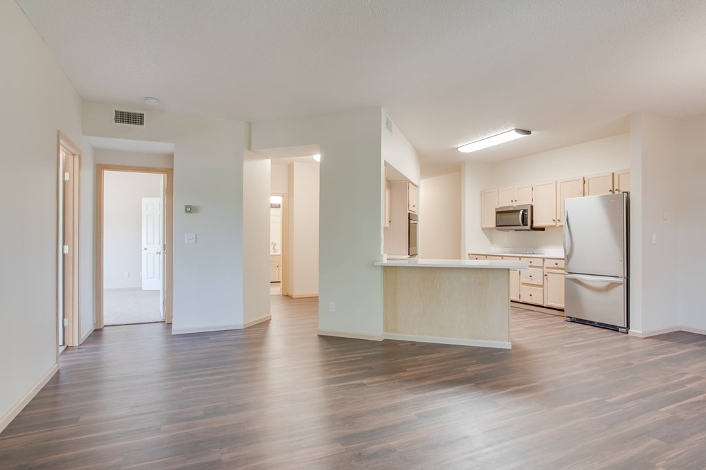 A kitchen area with a refrigerator, sink, and cabinets. at Eighth Street Manor Apartments, North Dakota