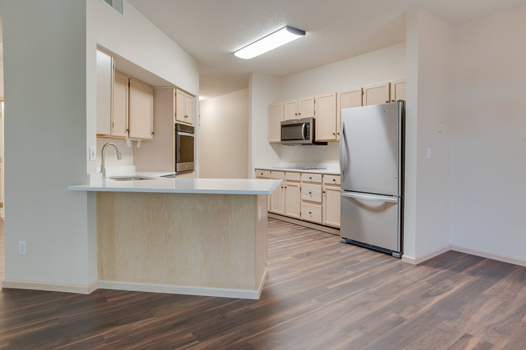 A kitchen with wooden floors and a white refrigerator. at Eighth Street Manor Apartments, Fargo, ND, 58103