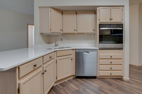 A kitchen with wooden cabinets and a white countertop.