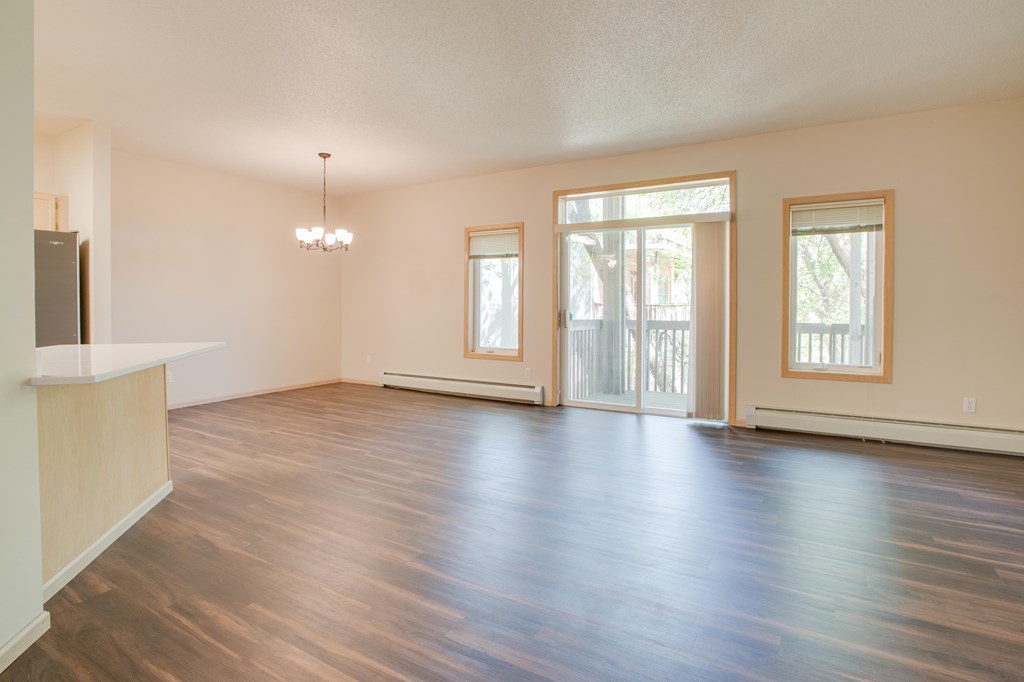 A room with wooden floors and a chandelier. at Eighth Street Manor Apartments, North Dakota, 58103