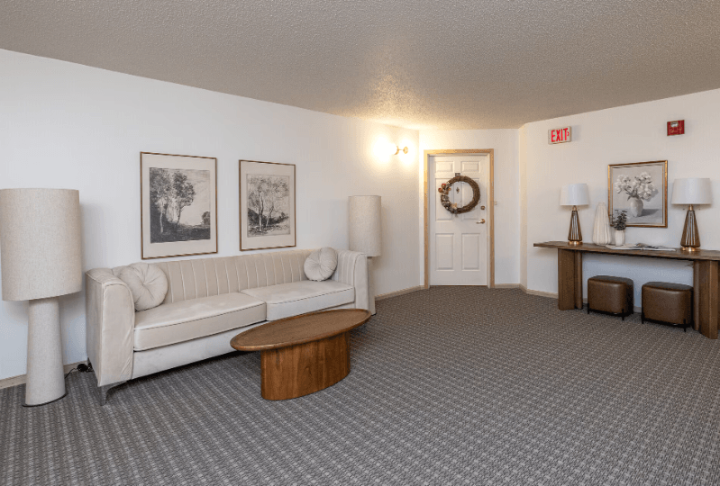 A living room with a couch, two lamps, and a coffee table at Eighth Street Manor Apartments, Fargo, ND, 58103