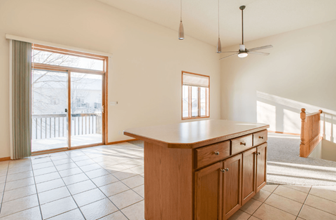 A kitchen with a wooden counter and tile floor.