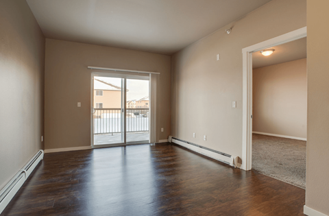 A room with a sliding glass door leading to a balcony.