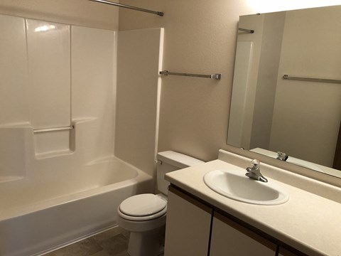 A white toilet sits next to a white sink in a small bathroom.
