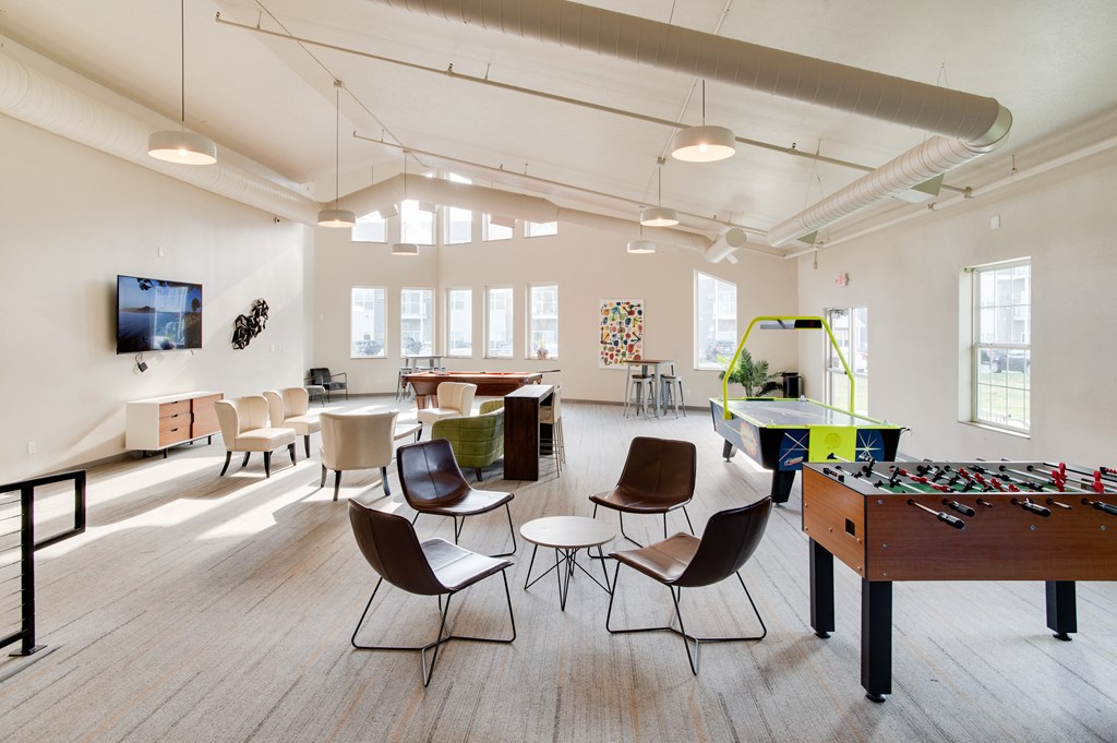 a game room with a foosball table and a flat screen tv