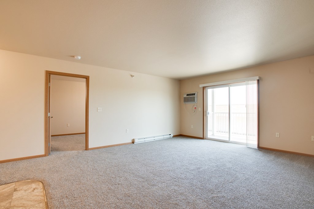 the living room of an empty house with a door to the bedroom