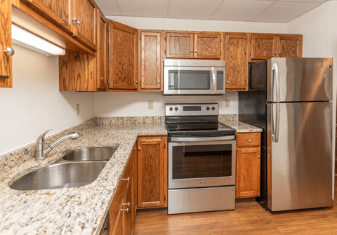 A kitchen with a stove, oven, sink, and refrigerator.