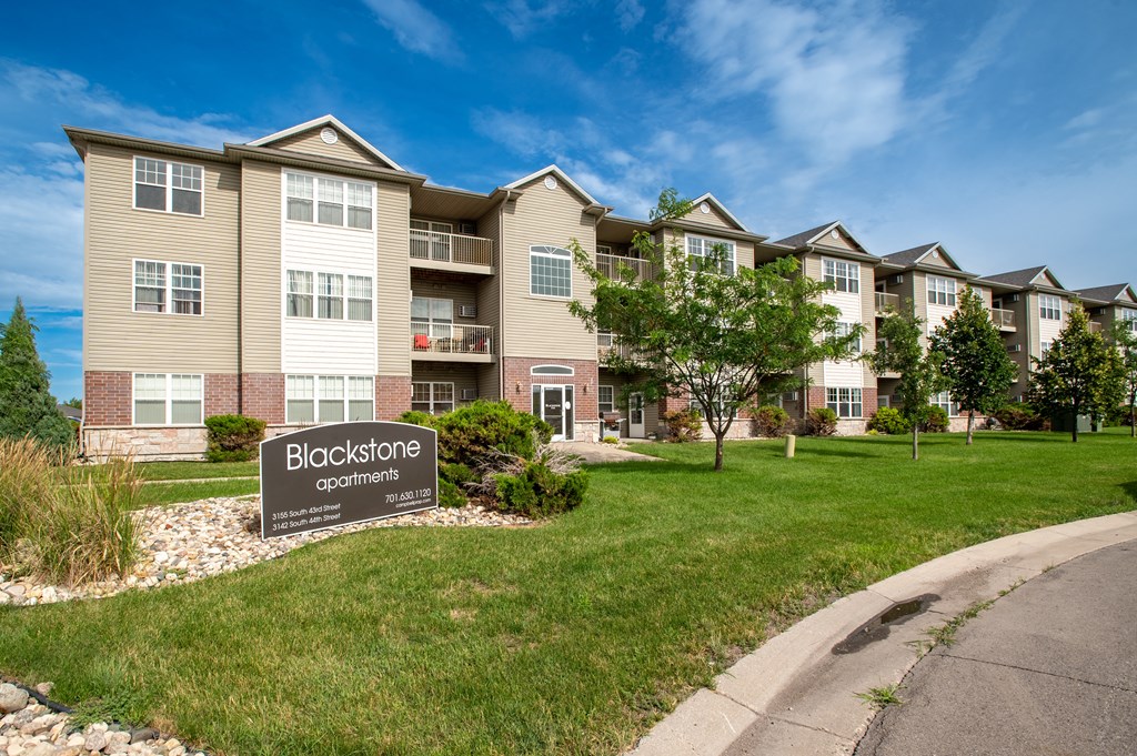 an apartment building with a sign that reads bioscience commons at BlackstoneApartments, Fargo, ND, 58104