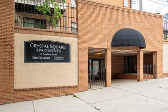 a brick building with a black sign that reads crystals square apartments