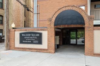 a brick building with a black sign that reads walter square apartments