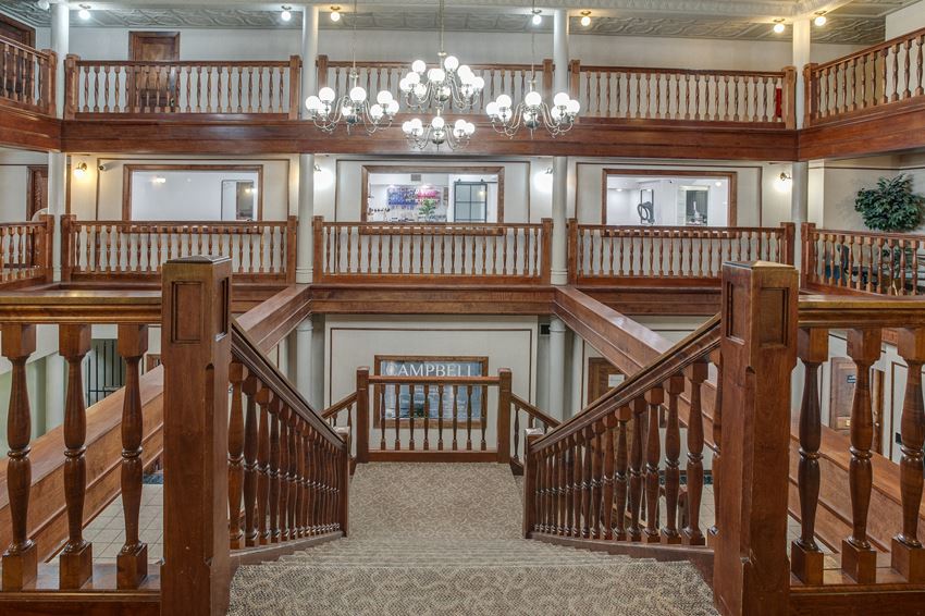 a view from the top of the stairs looking down at the second and third floors of the