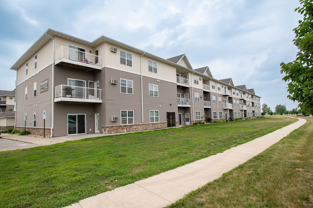 a large apartment complex with a grassy area in front of it at Boulder Ridge Apartments, Fargo