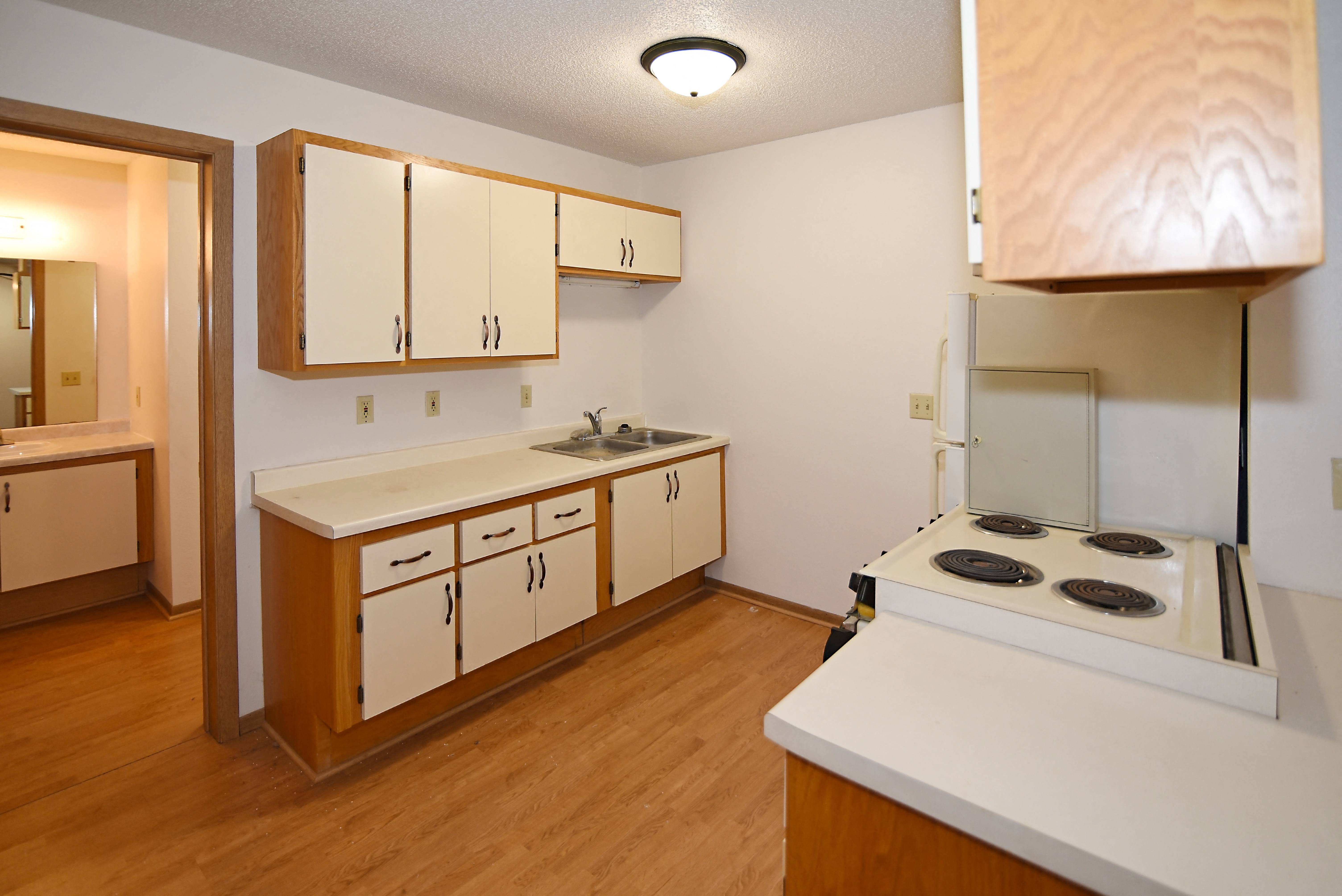 a kitchen with white cabinets and a stove and a sink