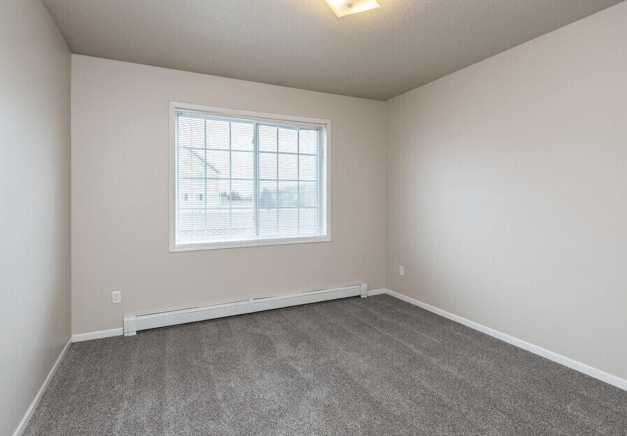 A room with a carpeted floor and a window at Courtyard Apartments on Belsly Apartments, Moorhead, 56560