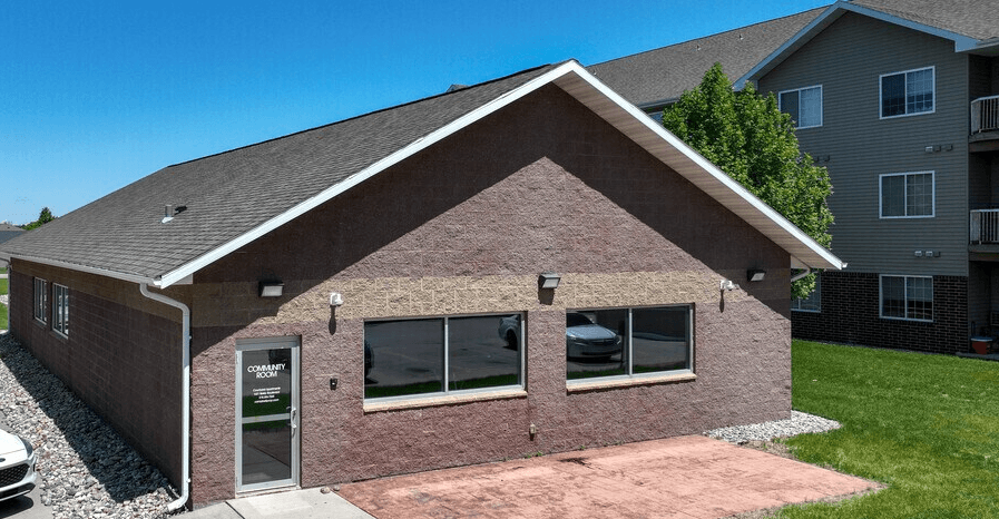 A house with a brown brick exterior and a grey roof at Courtyard Apartments on Belsly Apartments, Moorhead