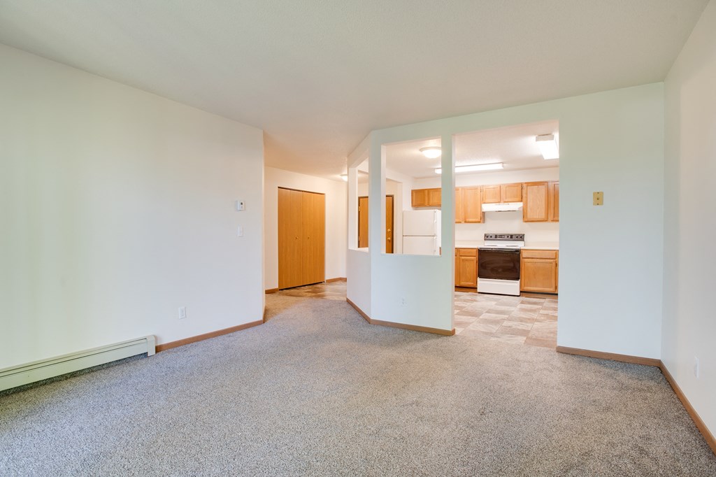 an empty living room with a kitchen in the background, Sandstone Apartments, Fargo, North Dakota