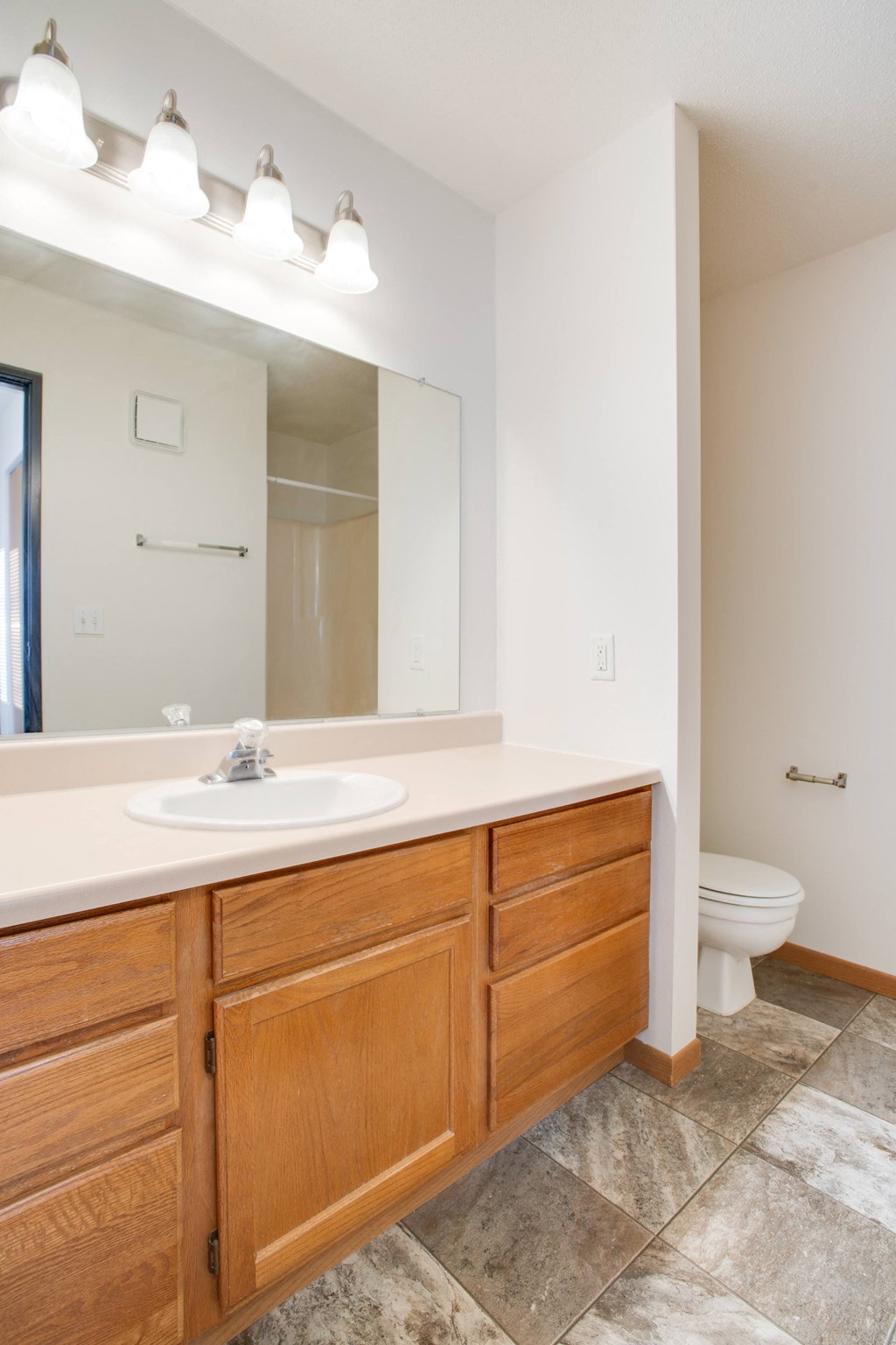 a bathroom with a large mirror and a sink and a toilet