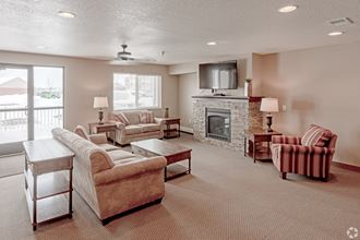 a living room with couches chairs and a fireplace  at Paraiso Estates, Sauk Rapids, 56379