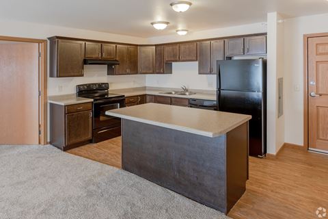 a kitchen with dark wood cabinets and a white counter top  at Paraiso Estates, Sauk Rapids, MN