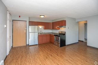 a kitchen with wood floors and white walls  at Southern Manor Apartments, Grand Forks