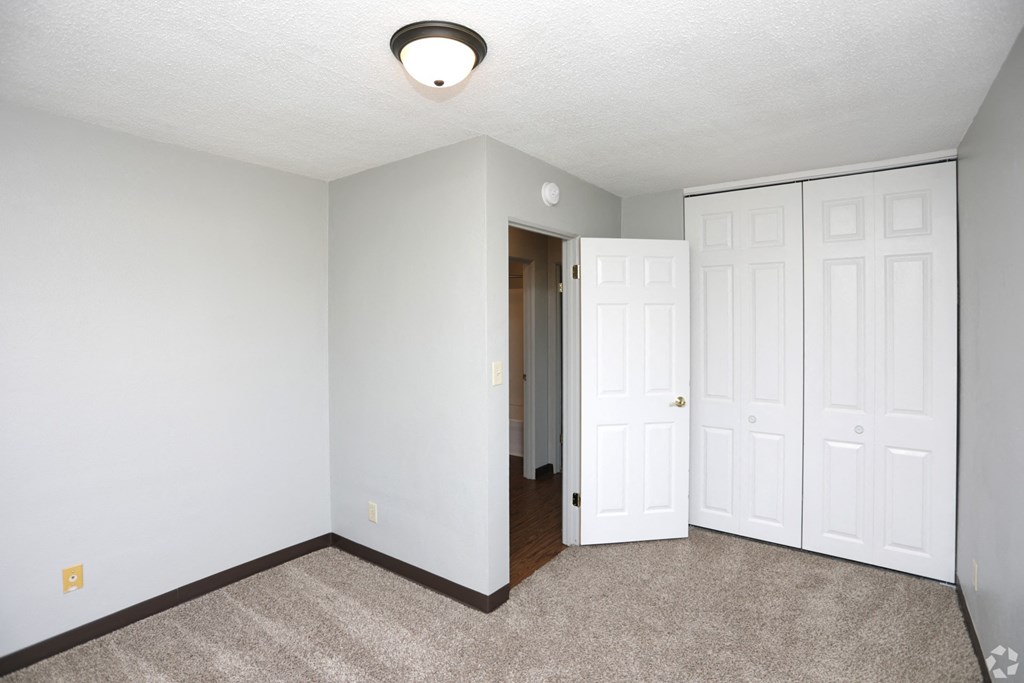a bedroom with two closets and a carpeted floor a bedroom with two closets and a carpeted floor at Southern Manor Apartments, North Dakota