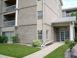 a large brick building with a grassy area in front of it  at Park Ridge Apartments, Fargo, ND