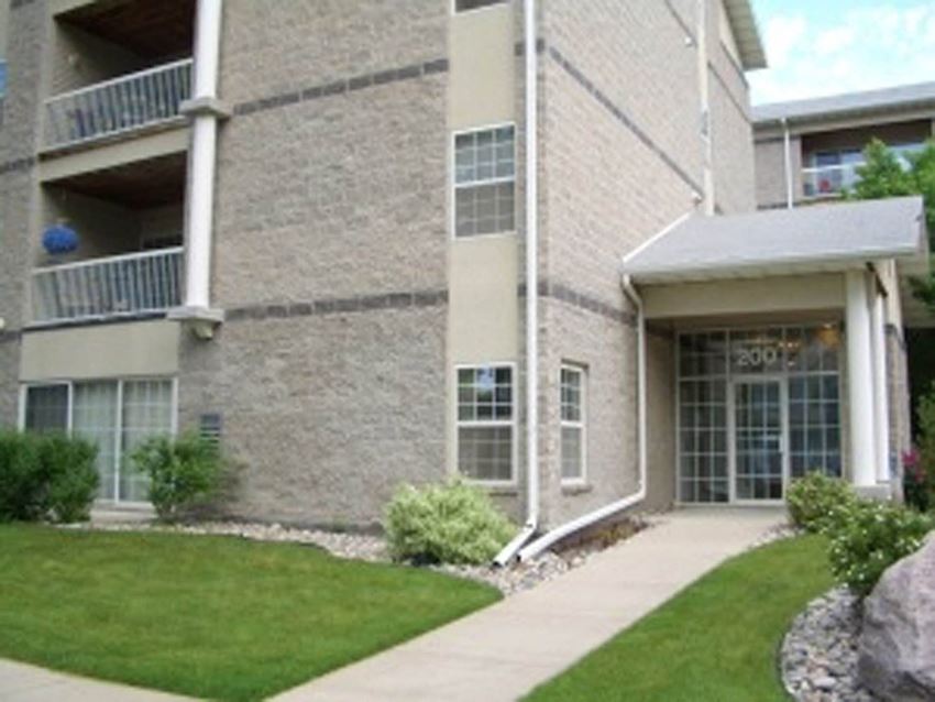 a large brick building with a grassy area in front of it a large brick building with a grassy area in front of it at Park Ridge Apartments, Fargo, ND - Photo Gallery